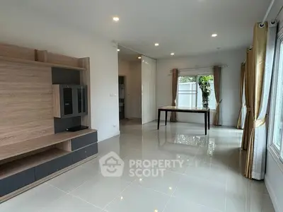 Spacious modern living room with sleek tile flooring and large windows for natural light.