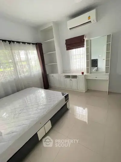 Spacious bedroom with built-in storage and natural light, featuring air conditioning and modern design.