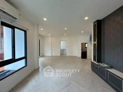 Spacious modern living room with large windows and elegant flooring