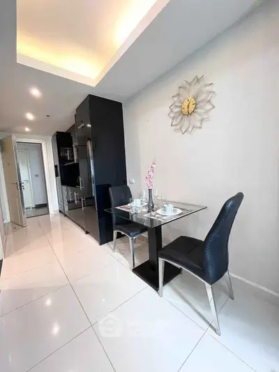 Modern kitchen with sleek black cabinets and stylish dining area in a bright apartment.