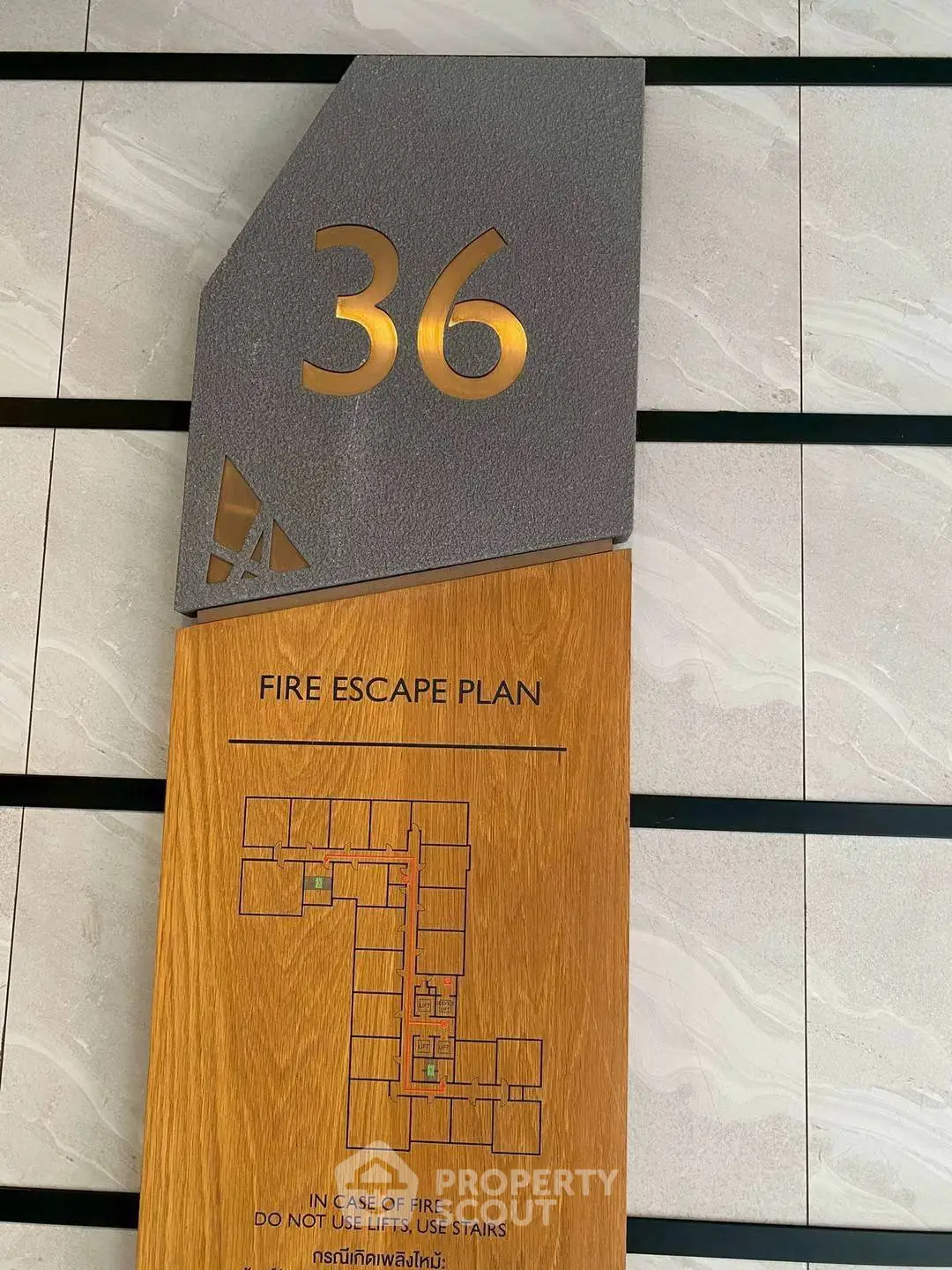 Modern fire escape plan on a stylish wooden plaque in a contemporary building.