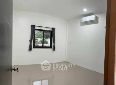 Spacious empty room with window view and air conditioning, perfect for customization.
