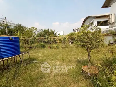 Spacious garden area with lush greenery and modern architecture in the background.