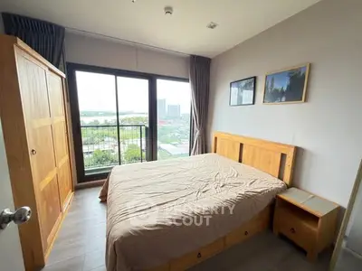 Cozy bedroom with wooden furniture and large window offering scenic city view