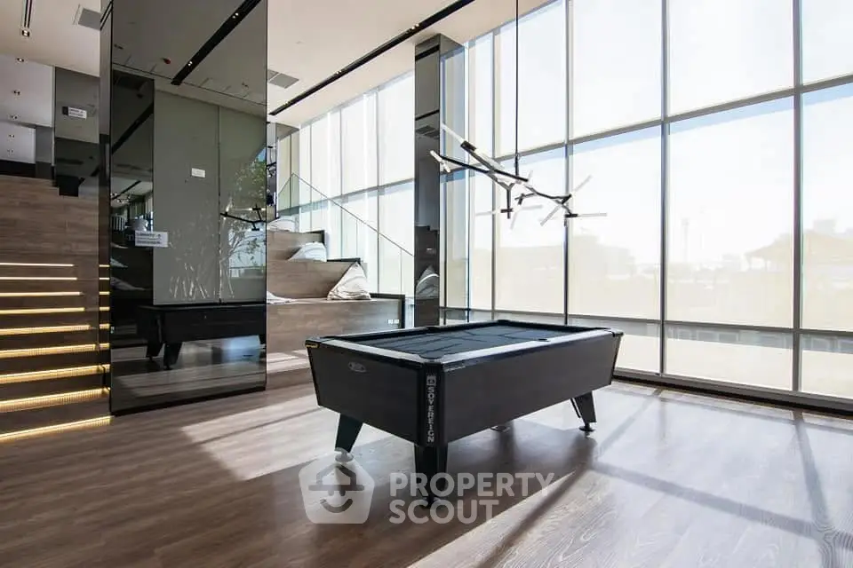 Luxurious modern interior with pool table and floor-to-ceiling windows in a stylish living space.