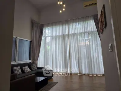 Spacious living room with high ceilings and large windows, perfect for natural light and modern living.