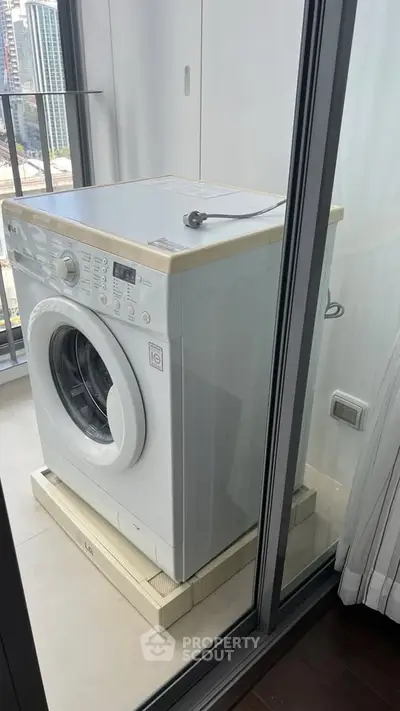 Modern washing machine on a balcony with city view, perfect for urban living convenience.