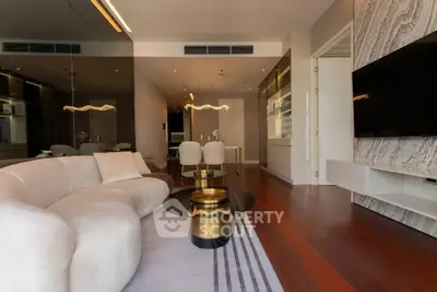 Luxurious modern living room with elegant furniture and stylish decor, featuring a sleek TV setup and warm lighting.