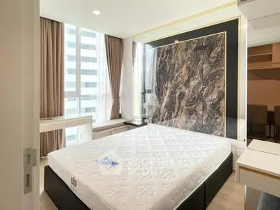 Luxurious bedroom with modern design and large window offering natural light.