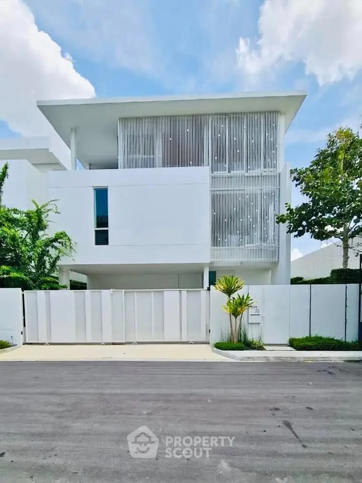 Modern minimalist white house with sleek lines and lush greenery, perfect for contemporary living.