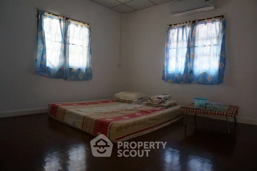 Cozy minimalist bedroom with simple mattress and air conditioning, perfect for a serene retreat.