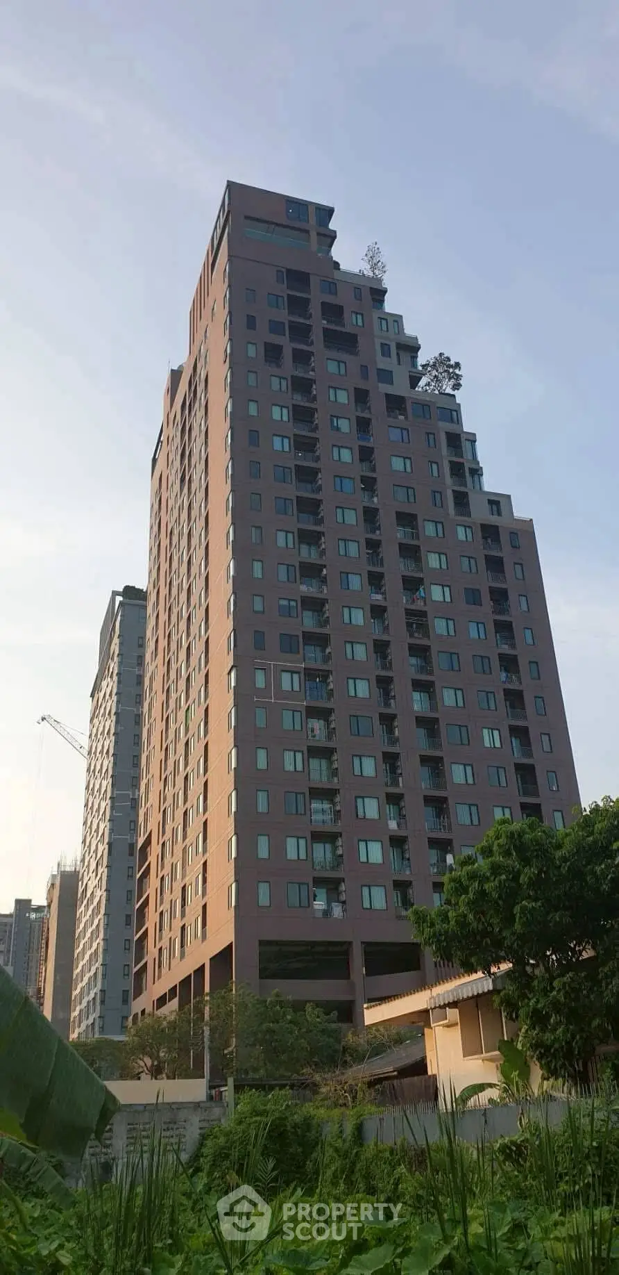 Stunning high-rise building with modern architecture and lush greenery, perfect for urban living.