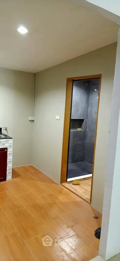 Modern interior with wooden flooring and sleek bathroom entrance