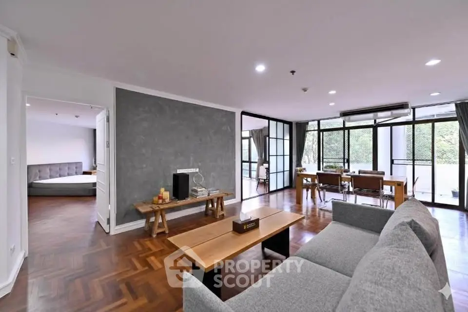 Spacious modern living room with large windows and stylish furniture, perfect for relaxation and entertaining.