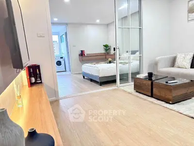 Modern living room with open view to bedroom and washing machine