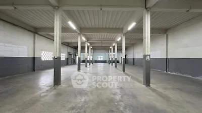 Spacious industrial warehouse with high ceilings and ample natural light, perfect for storage or manufacturing.