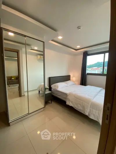 Modern bedroom with mirrored closet and scenic window view