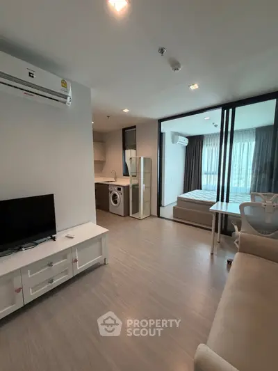 Modern apartment interior with living room, kitchen, and bedroom featuring sleek design and natural light.