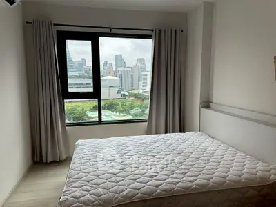 Modern bedroom with city view, featuring large window and minimalist decor.