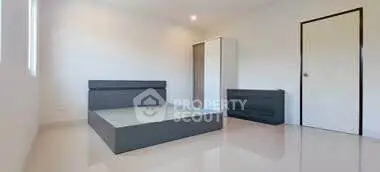 Minimalist bedroom with sleek furniture and glossy floors.