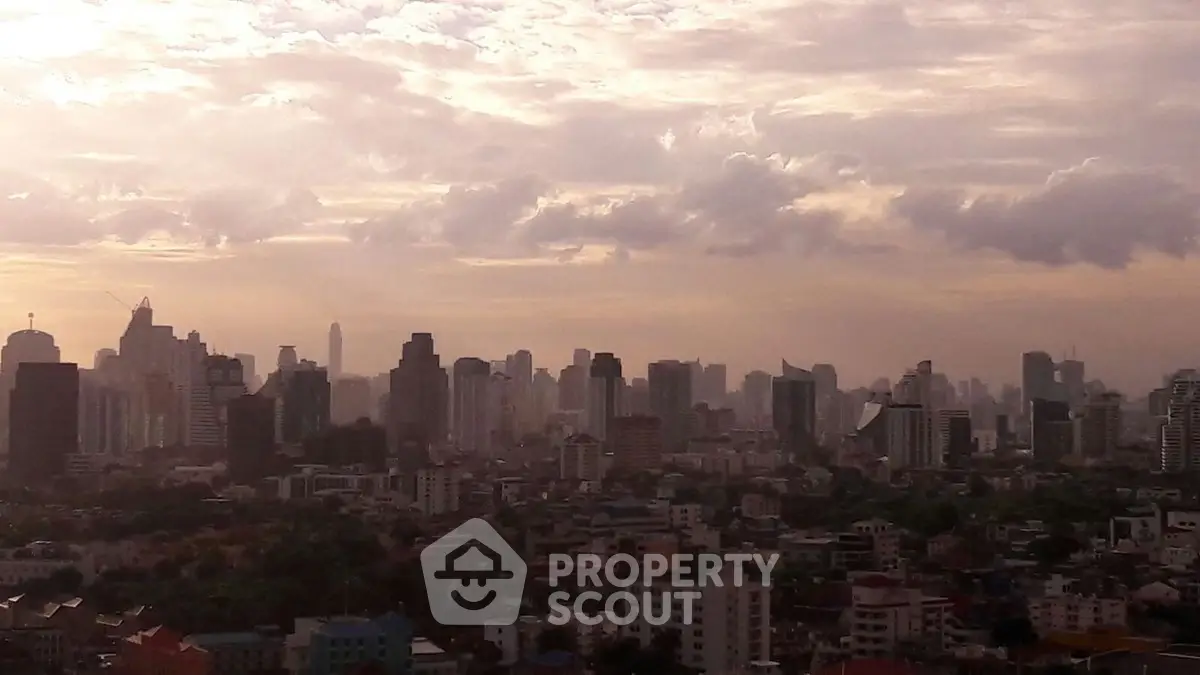 Stunning city skyline view at sunset with high-rise buildings and dramatic clouds.