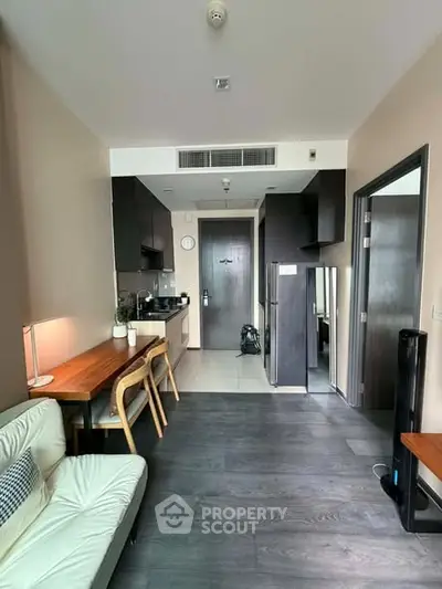 Modern apartment interior with sleek kitchen and cozy living area, featuring contemporary furniture and stylish decor.