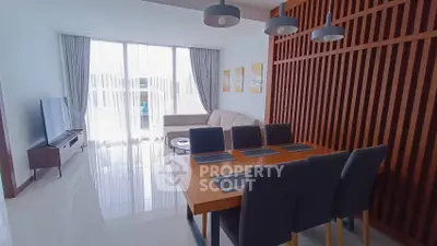 Modern living room with dining area, stylish decor, and natural light from large windows.