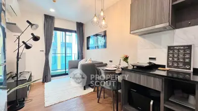 Modern living room with open kitchen, stylish decor, and balcony access in a chic apartment.