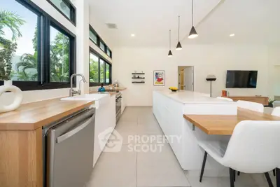 Spacious modern kitchen with open layout and sleek design, featuring large windows and stylish lighting.