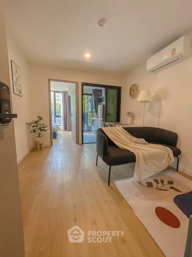 Modern living room with cozy decor and wooden flooring in a stylish apartment.