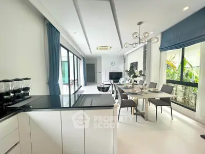 Modern open-plan living room with elegant dining area and large windows for natural light.