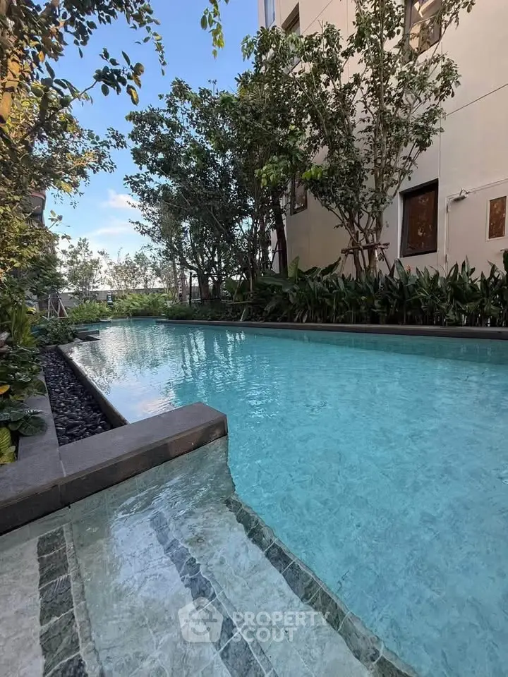 Luxurious residential pool surrounded by lush greenery and modern architecture.