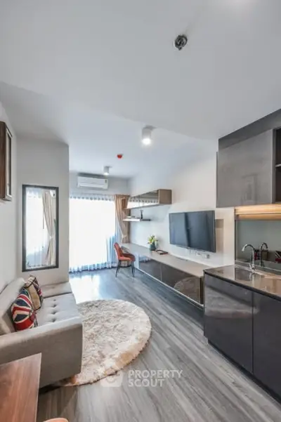 Modern living room with sleek kitchen, stylish decor, and natural light, perfect for urban living.