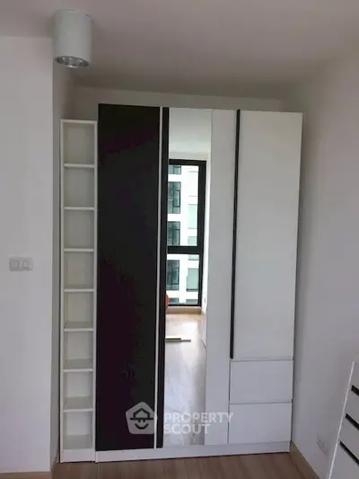 Modern bedroom with sleek wardrobe and large window view