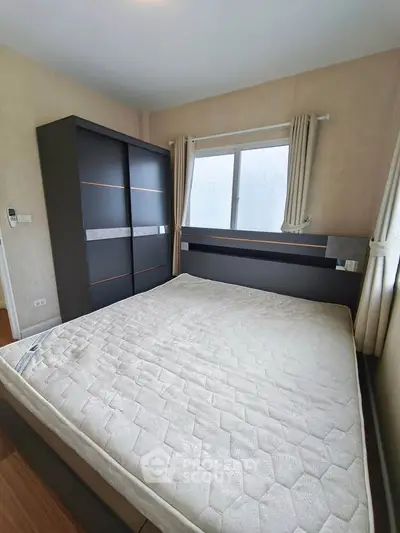 Spacious bedroom with modern wardrobe and large window for natural light