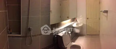 Modern bathroom with sleek tiles and contemporary fixtures in a stylish real estate property.