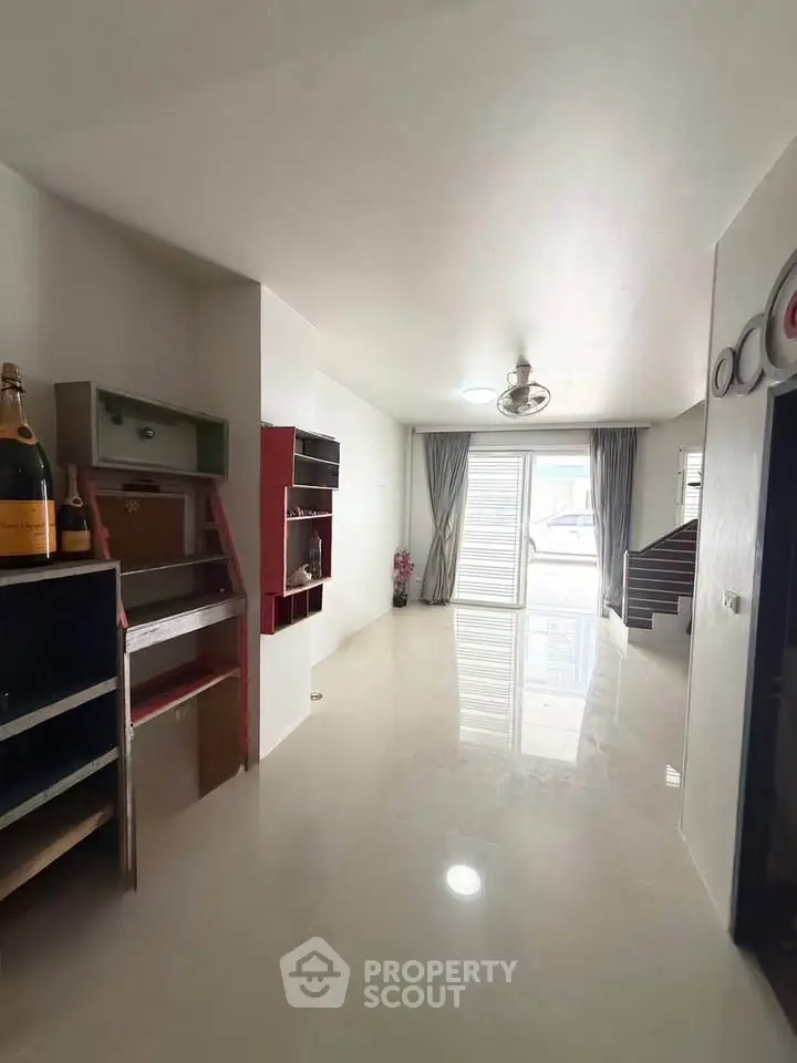 Spacious modern living room with sleek flooring and large windows for natural light.