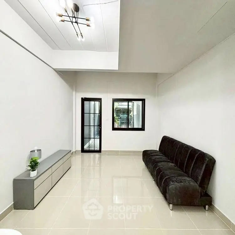 Spacious modern living room with sleek black sofa and elegant lighting