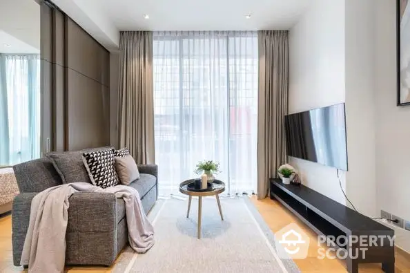 Elegant living room with plush seating, modern amenities, and abundant natural light streaming through sheer curtains, perfect for upscale urban living.