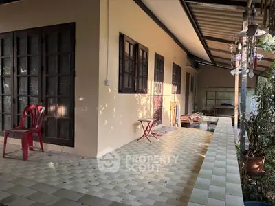 Charming outdoor patio with tiled flooring and cozy seating area, perfect for relaxation.