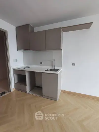 Modern minimalist kitchen with sleek cabinetry and compact design, perfect for urban living.