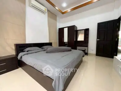 Spacious modern bedroom with sleek furniture and neutral tones