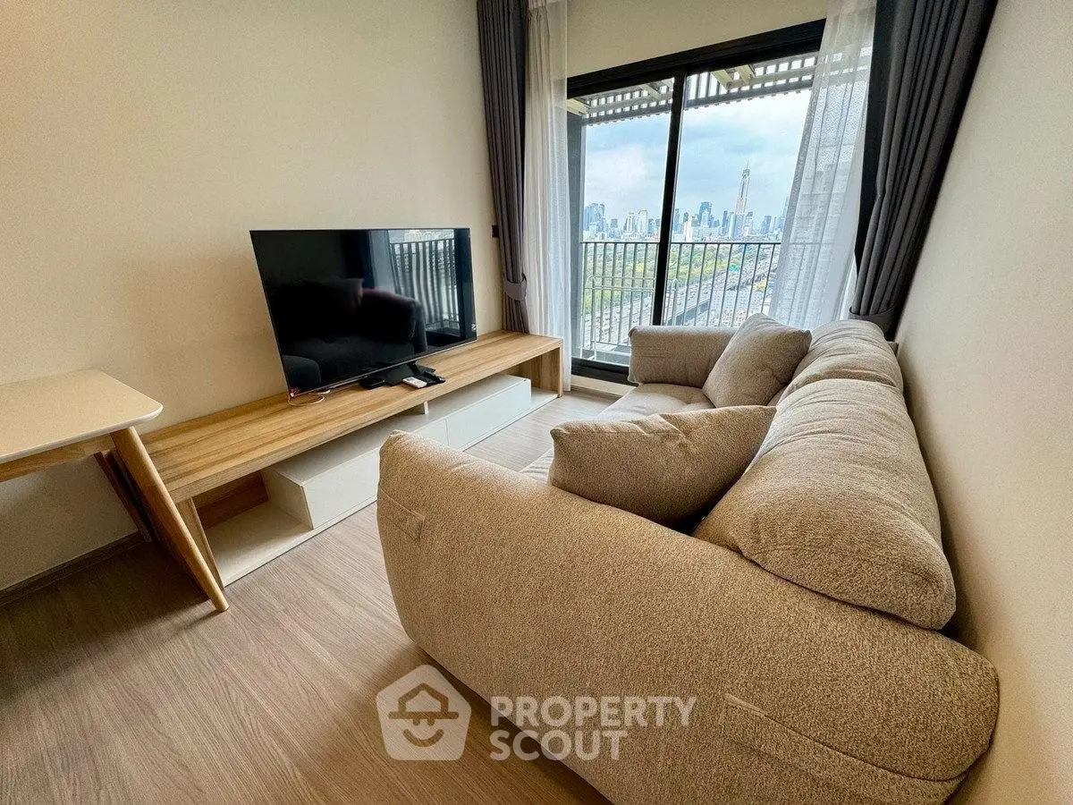 Modern living room with cozy sofa and city view from balcony