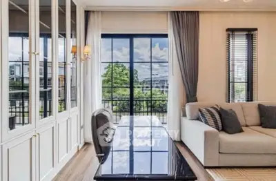 Elegant living room with large windows and stylish decor, offering a bright and inviting atmosphere.