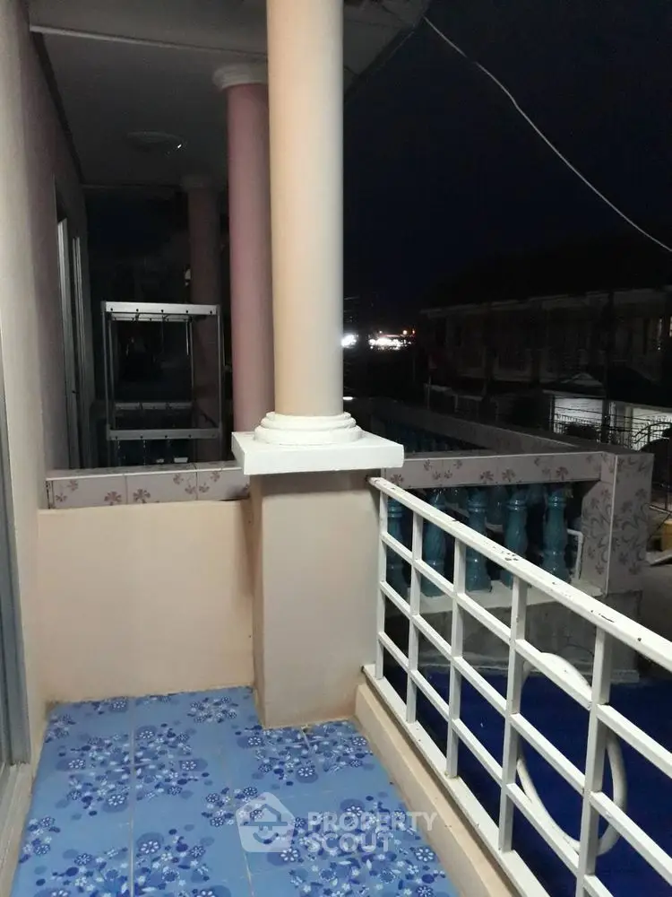 Charming balcony with decorative tiles and night view, perfect for relaxation.
