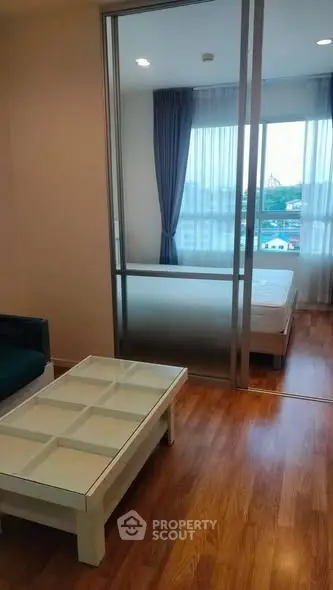 Modern apartment with glass partition and wooden flooring, offering a cozy and stylish living space.