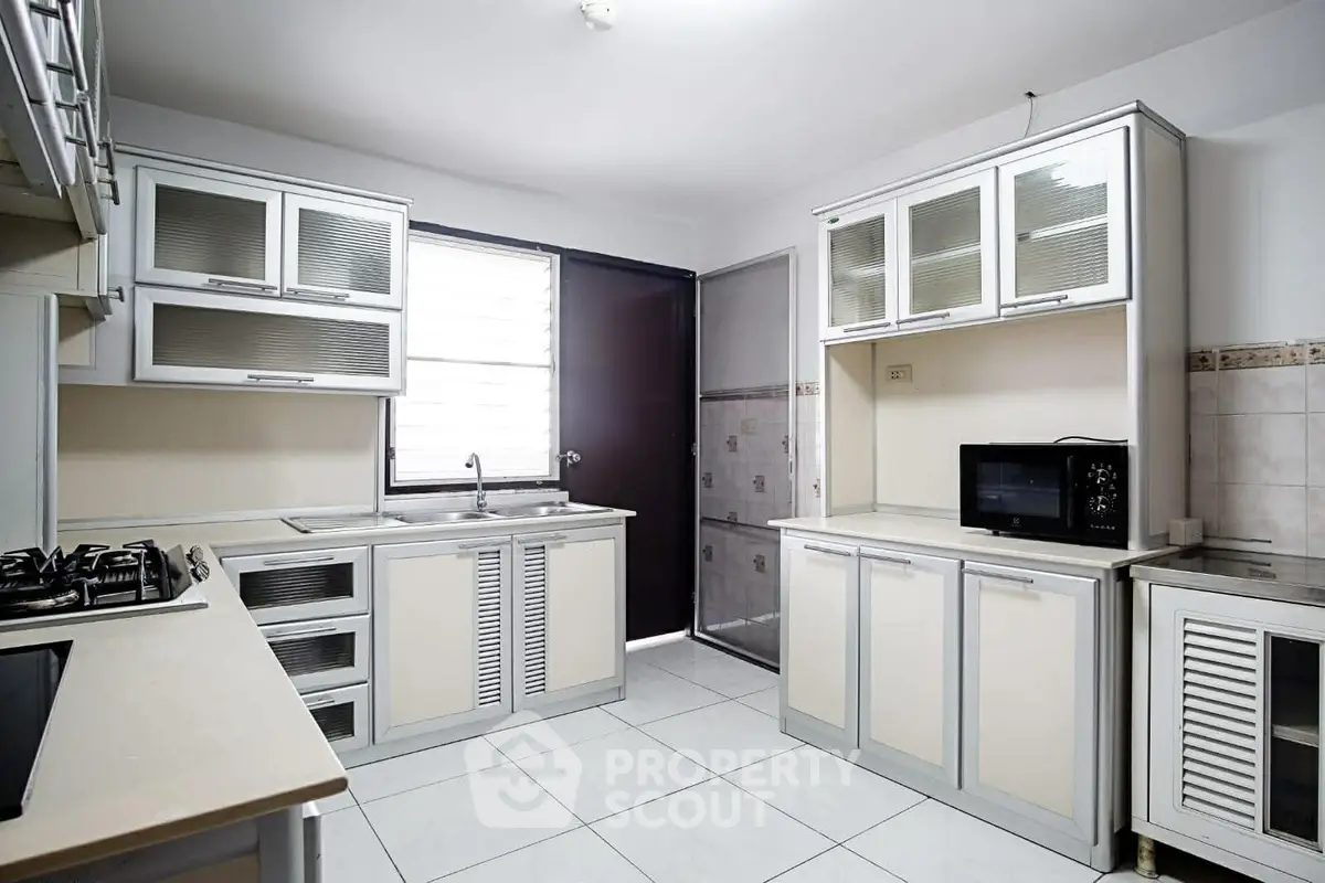 Modern kitchen with sleek cabinetry and gas stove in bright, airy space.