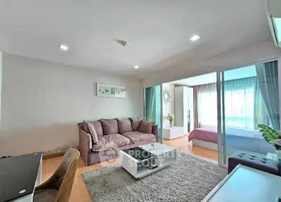 Spacious modern living room with cozy sofa and open view to bedroom