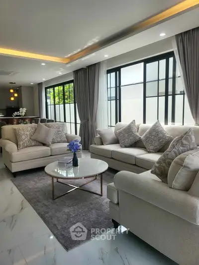 Luxurious living room with elegant sofas and large windows, perfect for relaxation and entertaining.