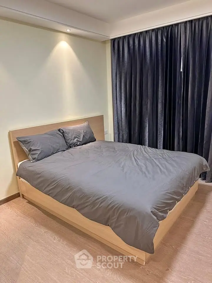 Modern bedroom with sleek design and cozy ambiance, featuring a comfortable bed and elegant curtains.